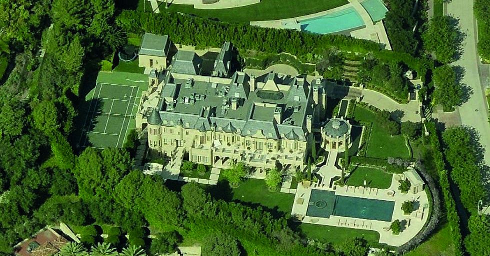 Twilight exterior of a large estate with pool and lawn