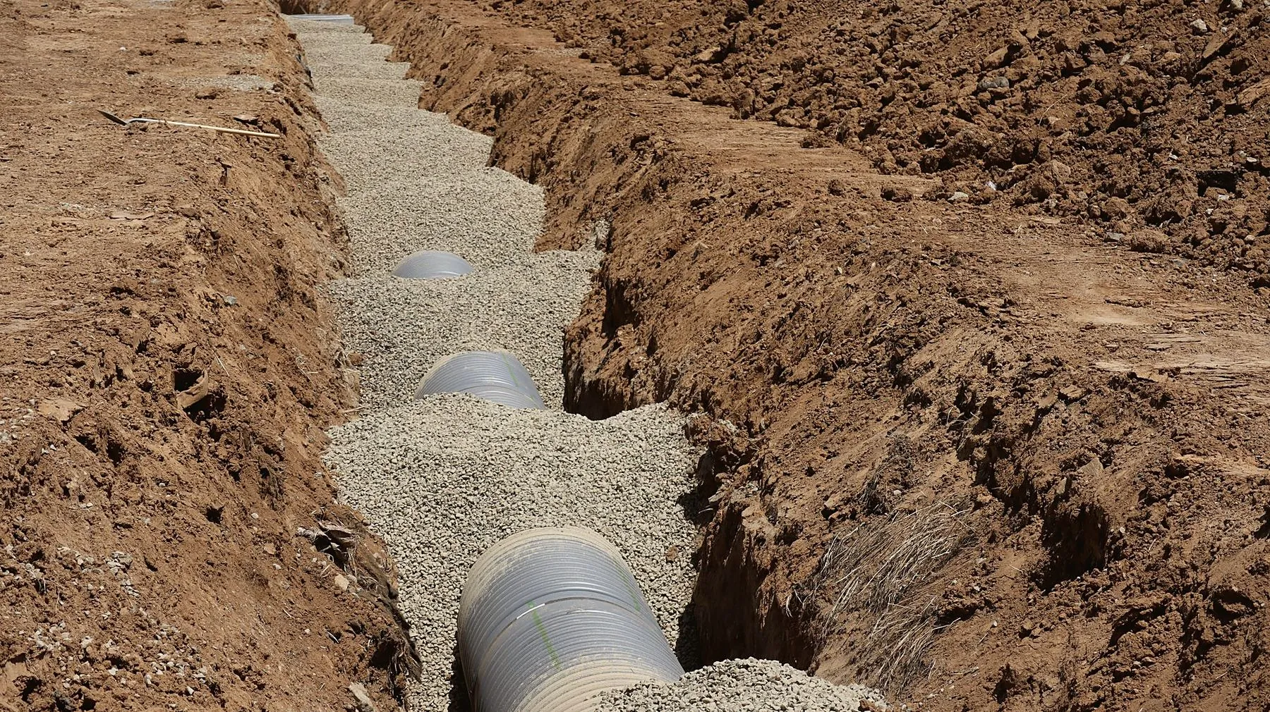 Sewer pipe on gravel bedding in a shored trench